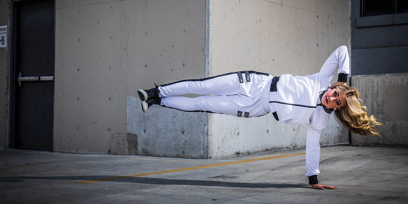 One of the Cougarettes holds herself parallel to the ground with one arm, the other arm resting on her head.