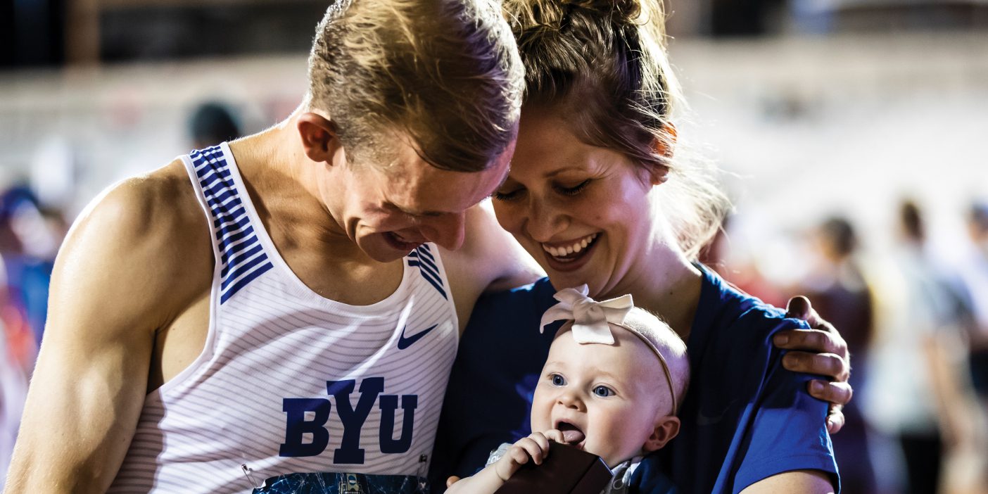 Clayton Young and his wife, Ashley, hold their baby, Lucy, as she puts his trophy in her mouth.