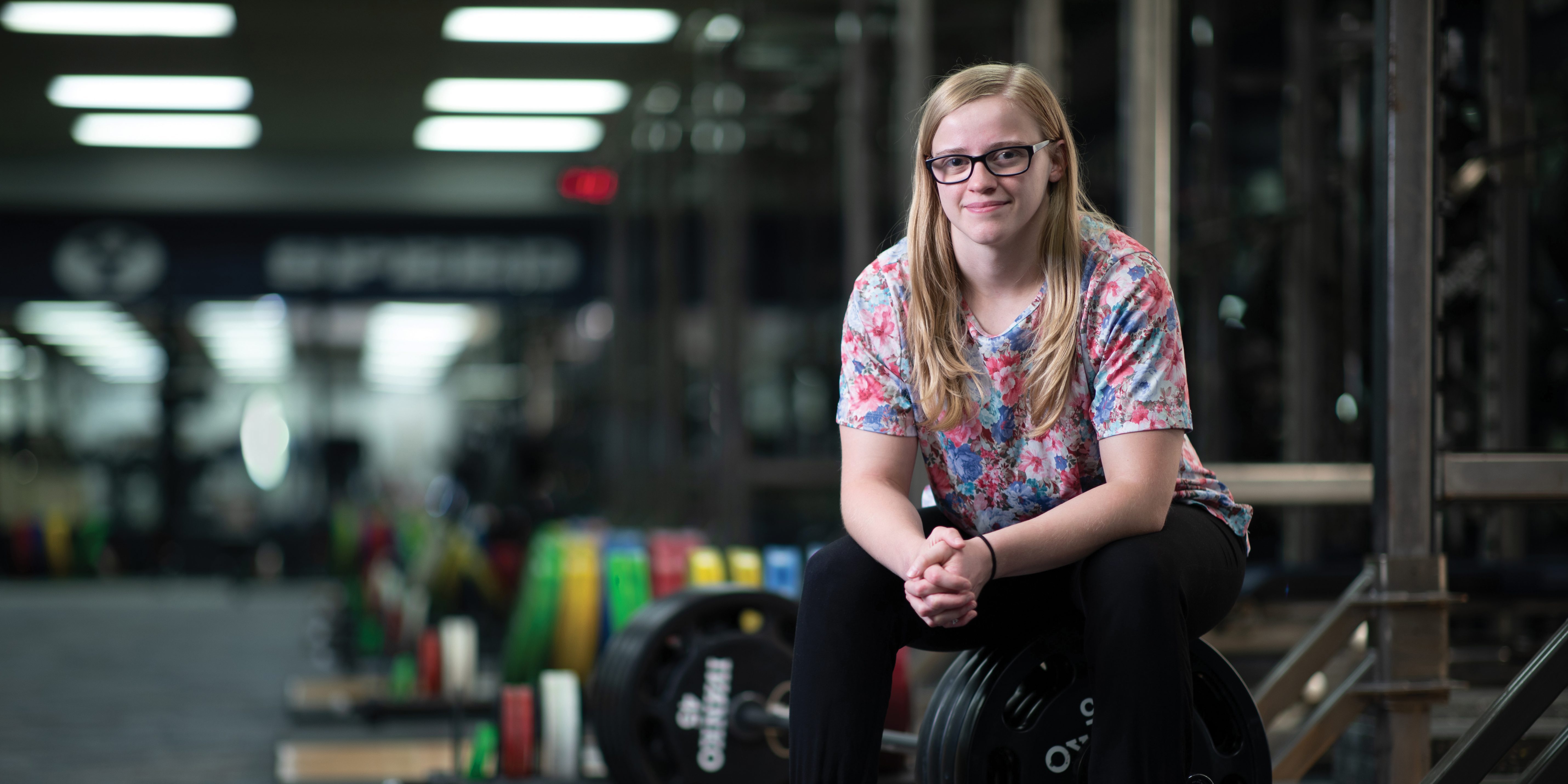 Jennica Baldridge sits on one end of a bar holding 410 pounds.