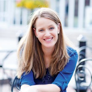 Melody Warnick sitting at a table and smiling.
