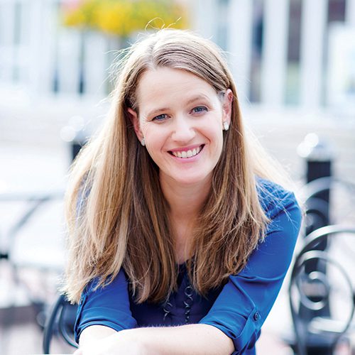 Melody Warnick sitting at a table and smiling.