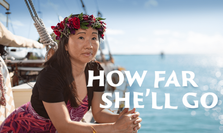 Linda Furuto leans over the side of the double-hulled canoe Hokulea.