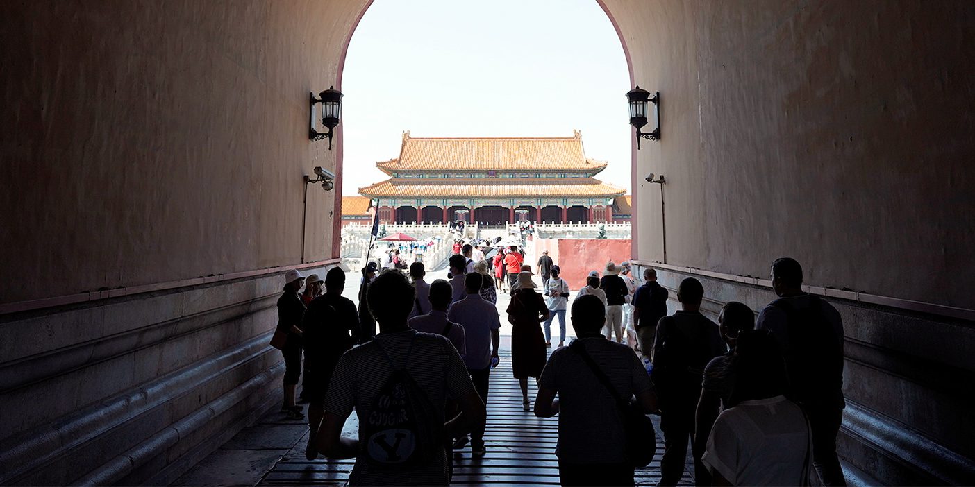 People walk through a tunnel in Beijing's Forbidden City.