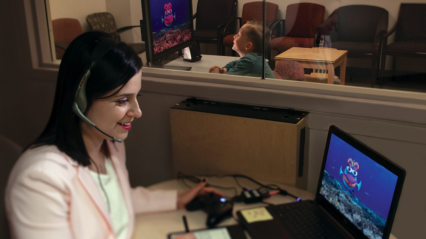 A woman interacts with an autistic boy via a computer animation of a talking fish.