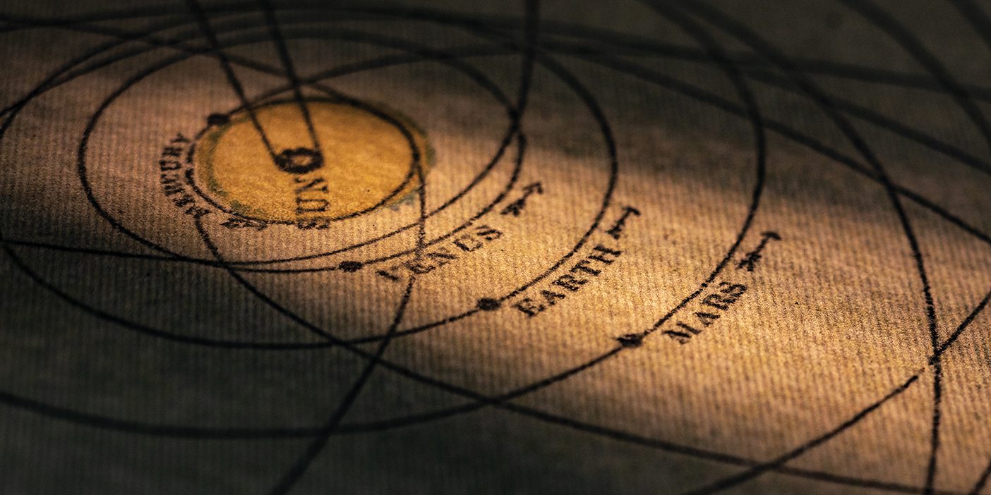 Light shines on a vintage map of the solar system showing the sun, Venus, Earth, and Mars.