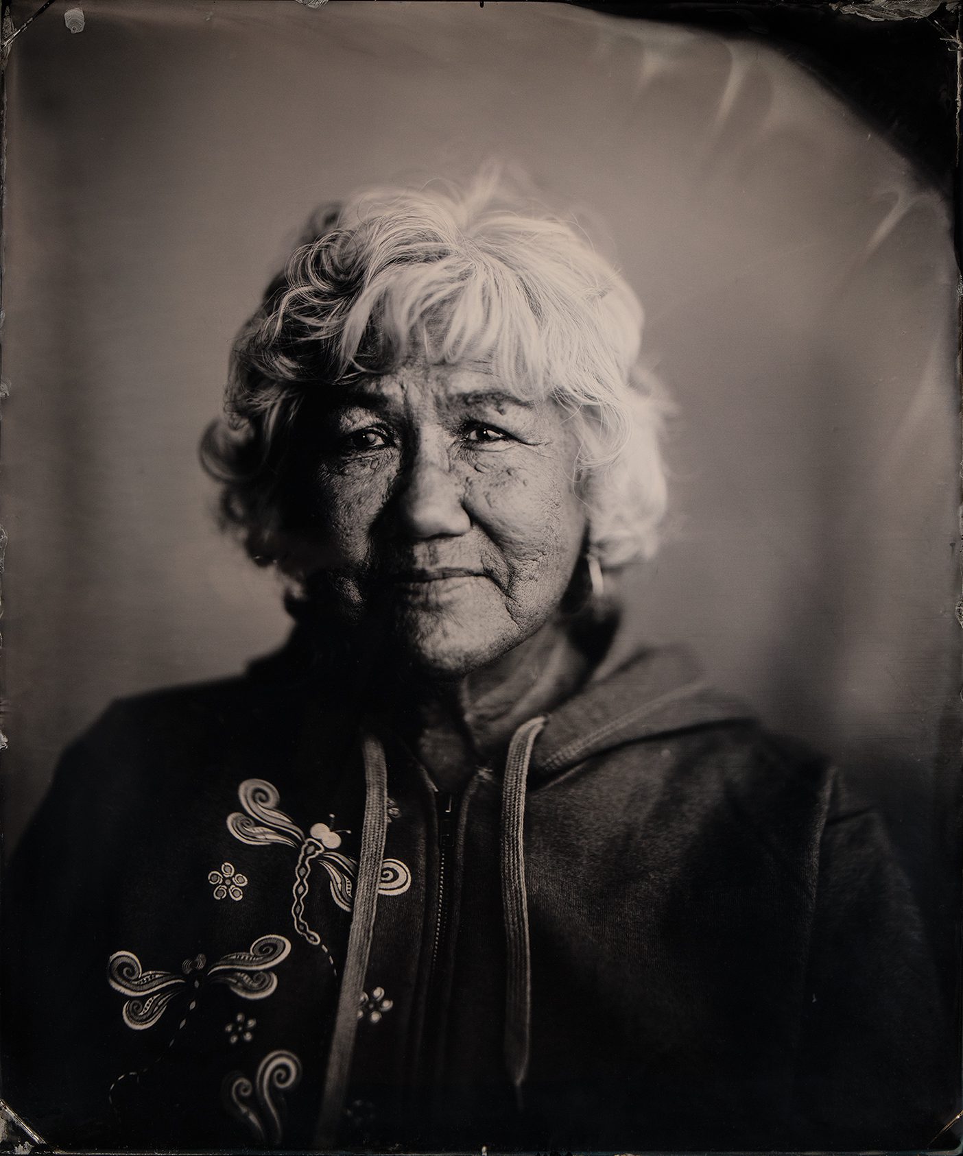 Black-and-white tintype photograph of a Native Alaskan woman in a jacket