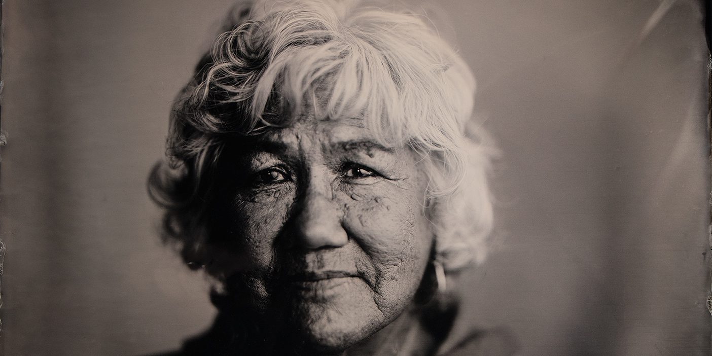 Black-and-white tintype photograph of a Native American woman wearing a jacket