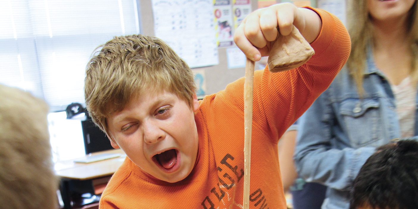 Fifth-grader Link Roper stretches a nylon sock filled with bananas in Anatomy Academy in his classroom.