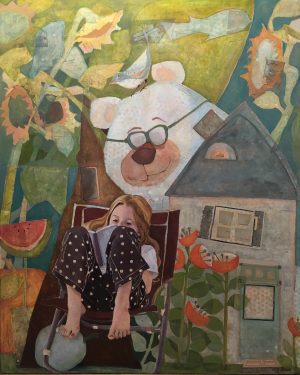 A little girl sits in a wooden chair while she reads in the garden.