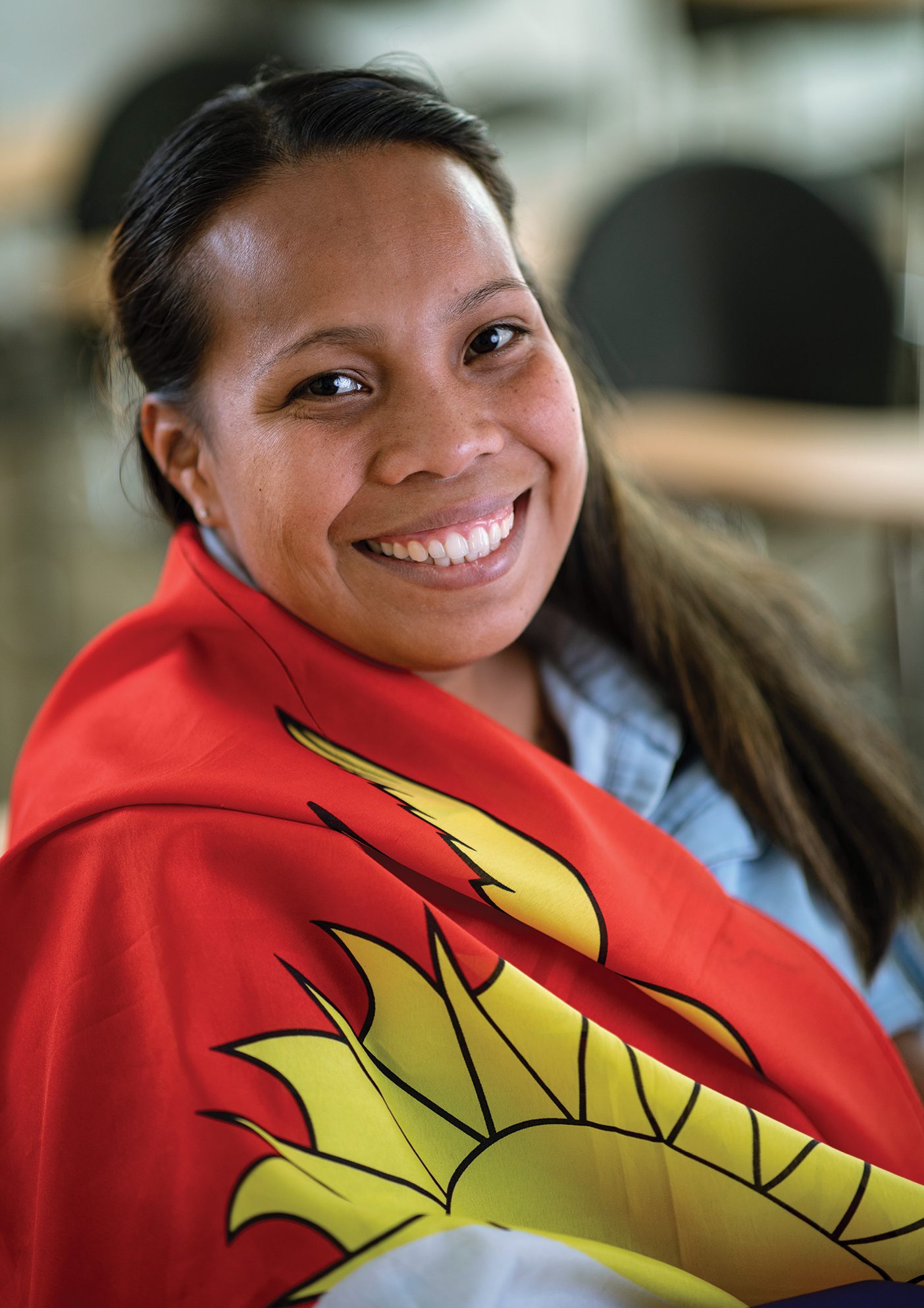 Tereua Kainitoka smiles with a Kiribati flag wrapped around her.