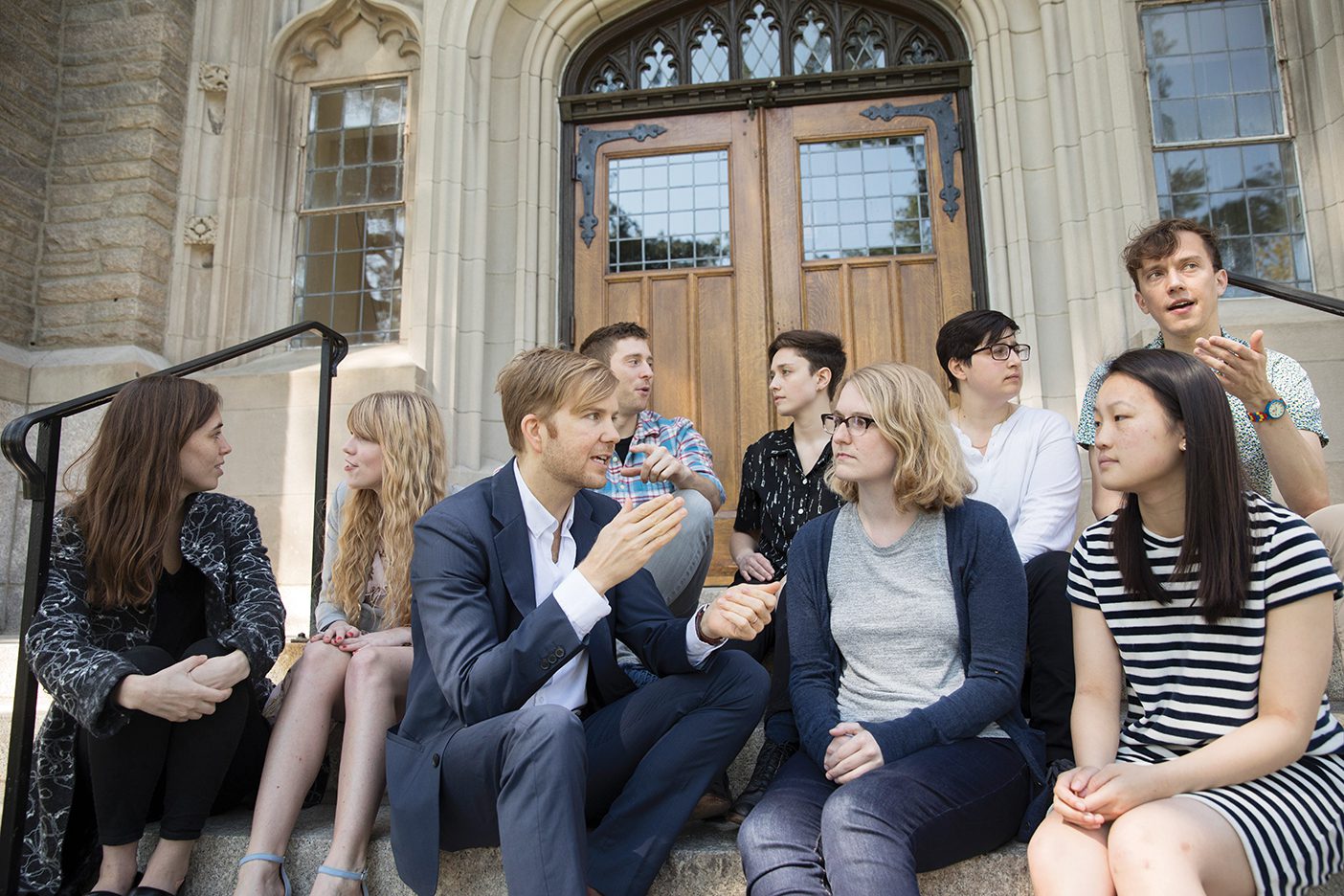 Zachary Davis and his Harvard team, which looks to be made up of students from Harvard, sit on the steps of an older building.