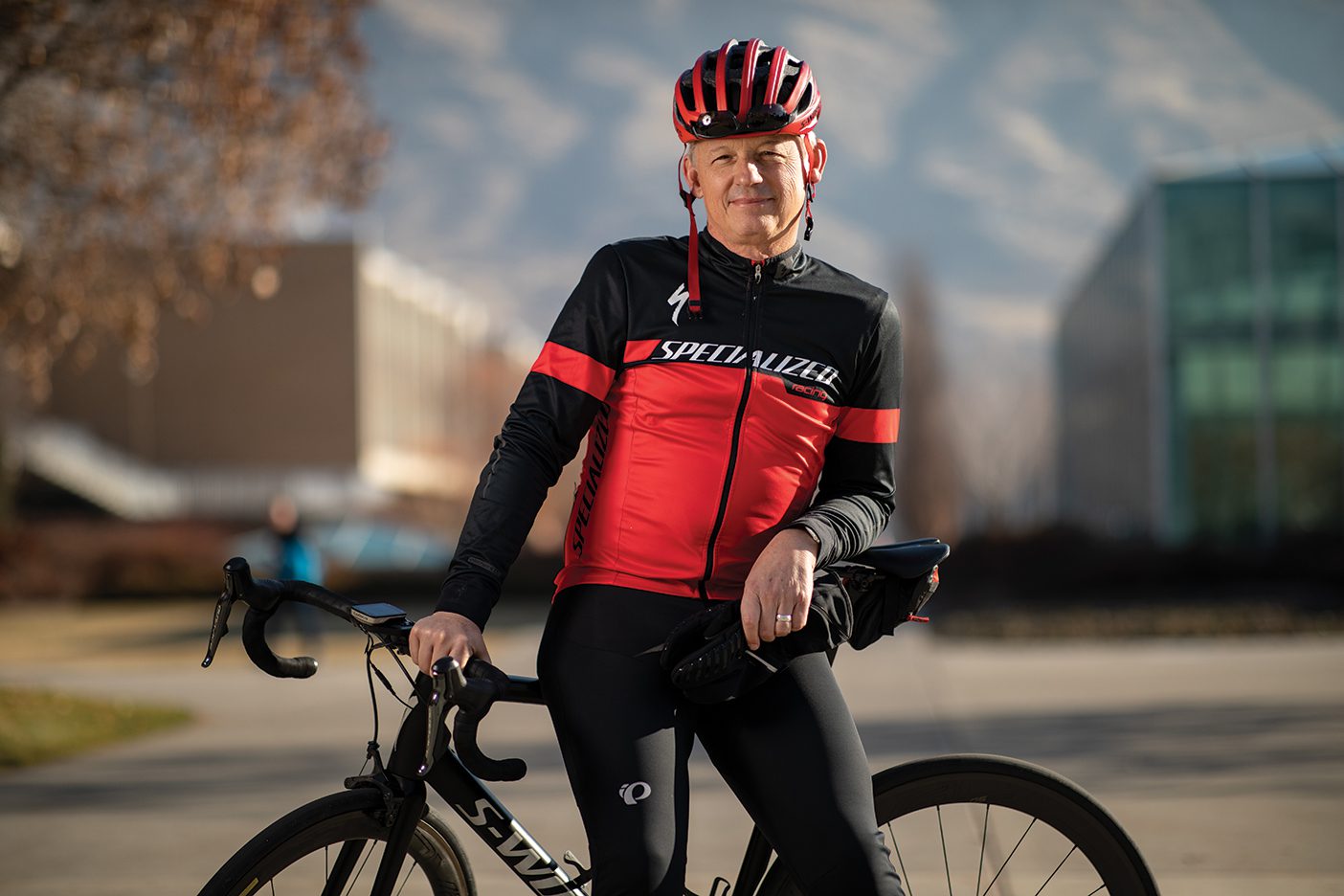 Michael Dunn in a biking outfit, standing by his bike.