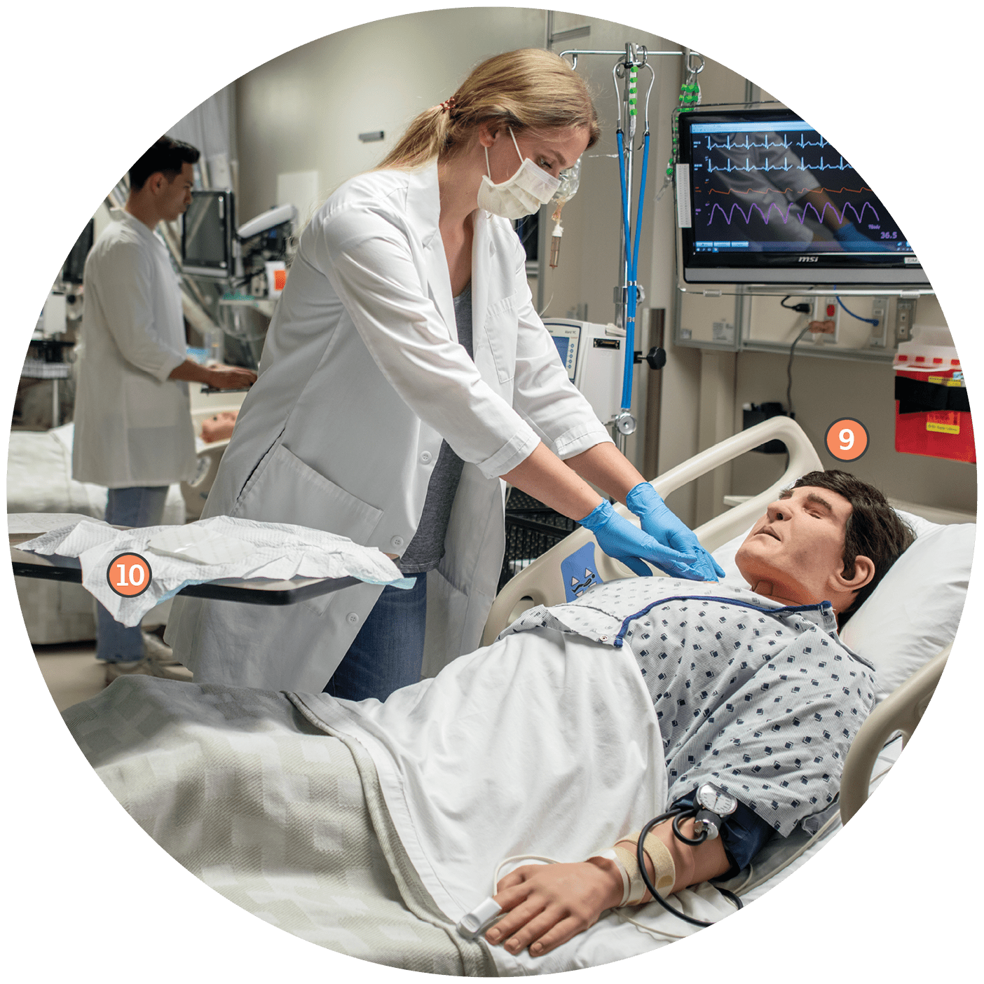 A circular image of the Mary Jane Rawlinson Geertsen Nursing Learning Center, featuring a high fidelity manikin and a nursing student doing a procedure on the manikin. A number 9 labels supplies on a work station. A number 10 annotates the manikin.