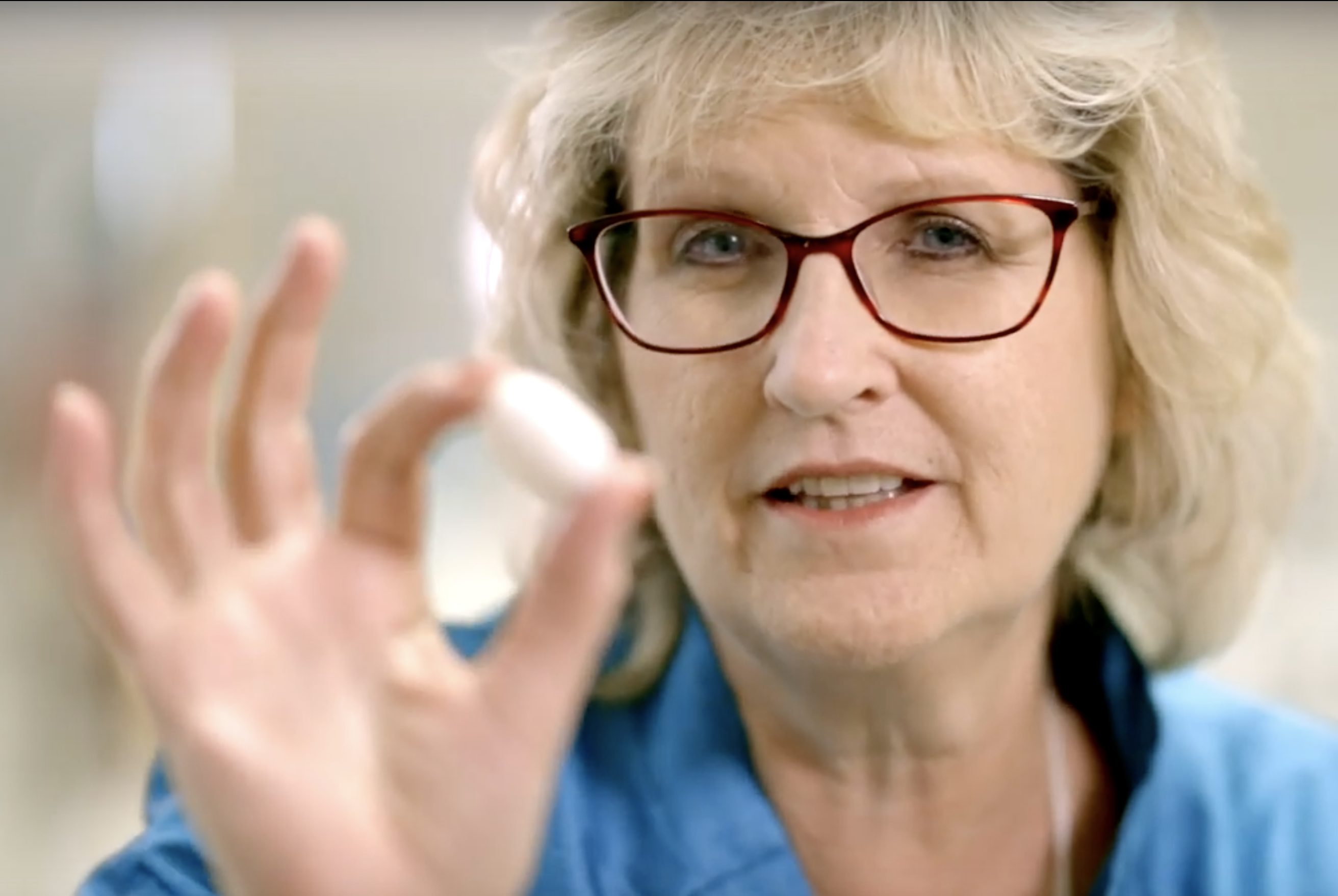 BYU family and consumer sciences professor Dawna Baugh holds up a silkworm cocoon.