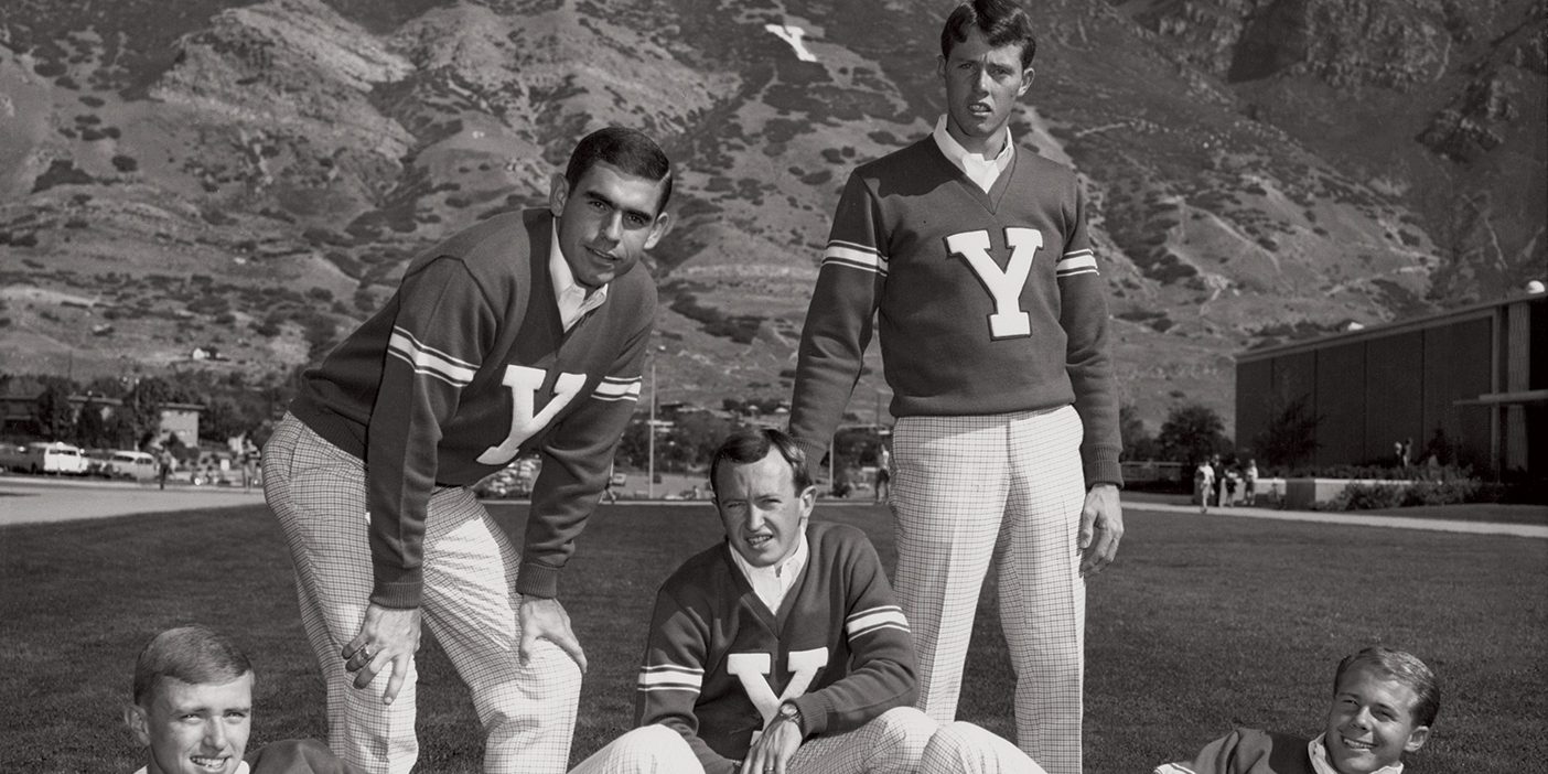 Five young male cheerleaders from 1968 wear plaid pants and sweaters with a big "Y" in the center.