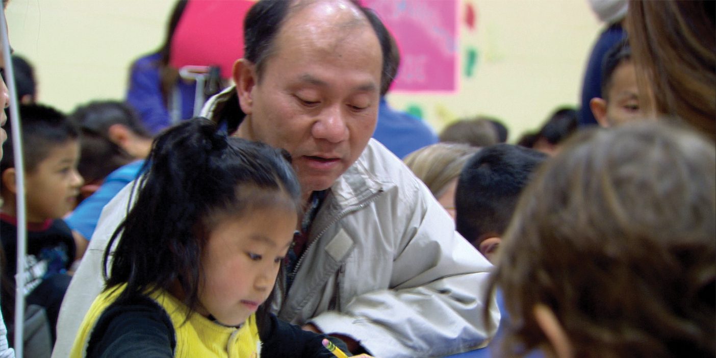 A father and daughter eat and work together.