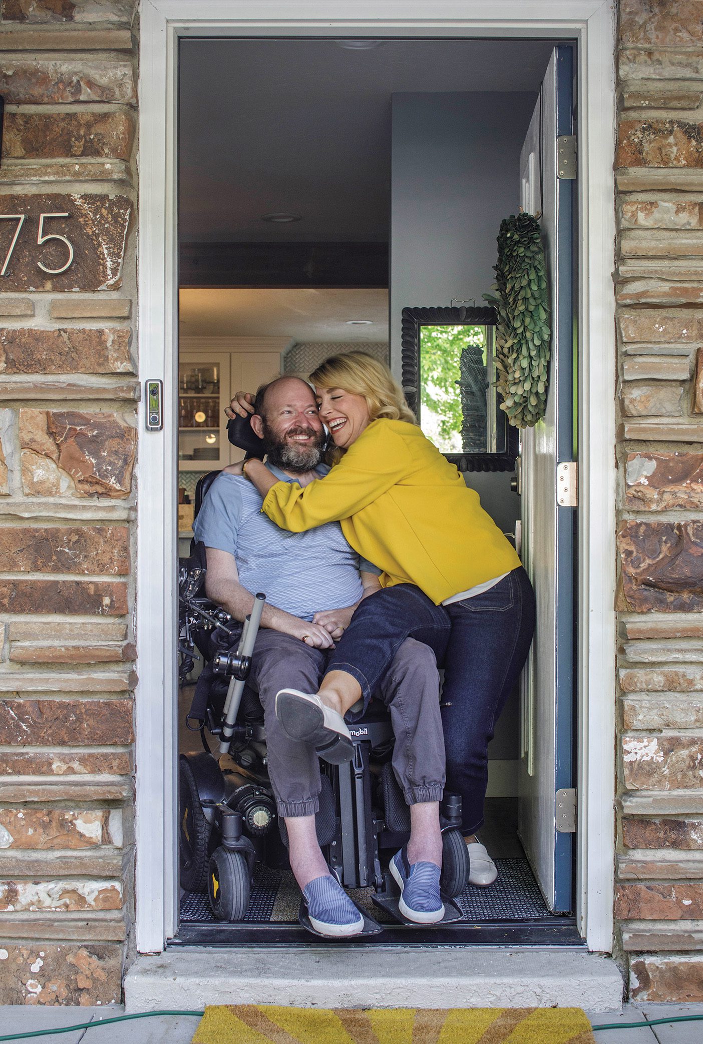 Lisa and Chris Clark hugging in their doorway.