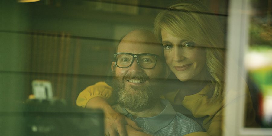 Chris and Lisa Clark looking through a window.