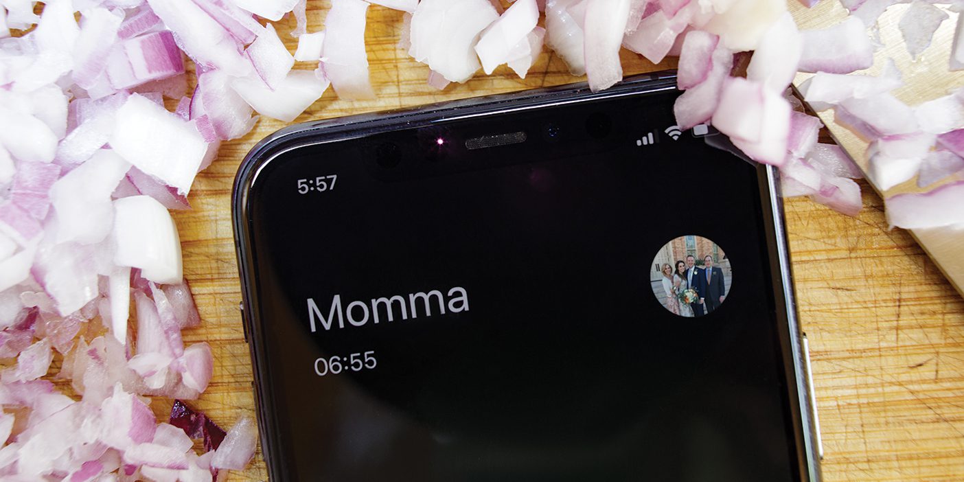 Diced onions on a cutting board border a smartphone showing a call in progress with Momma.