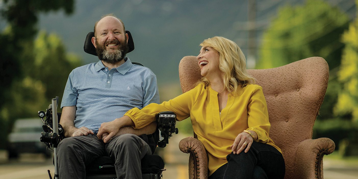 Chris and Lisa Clark posing together in the road in front of their home.