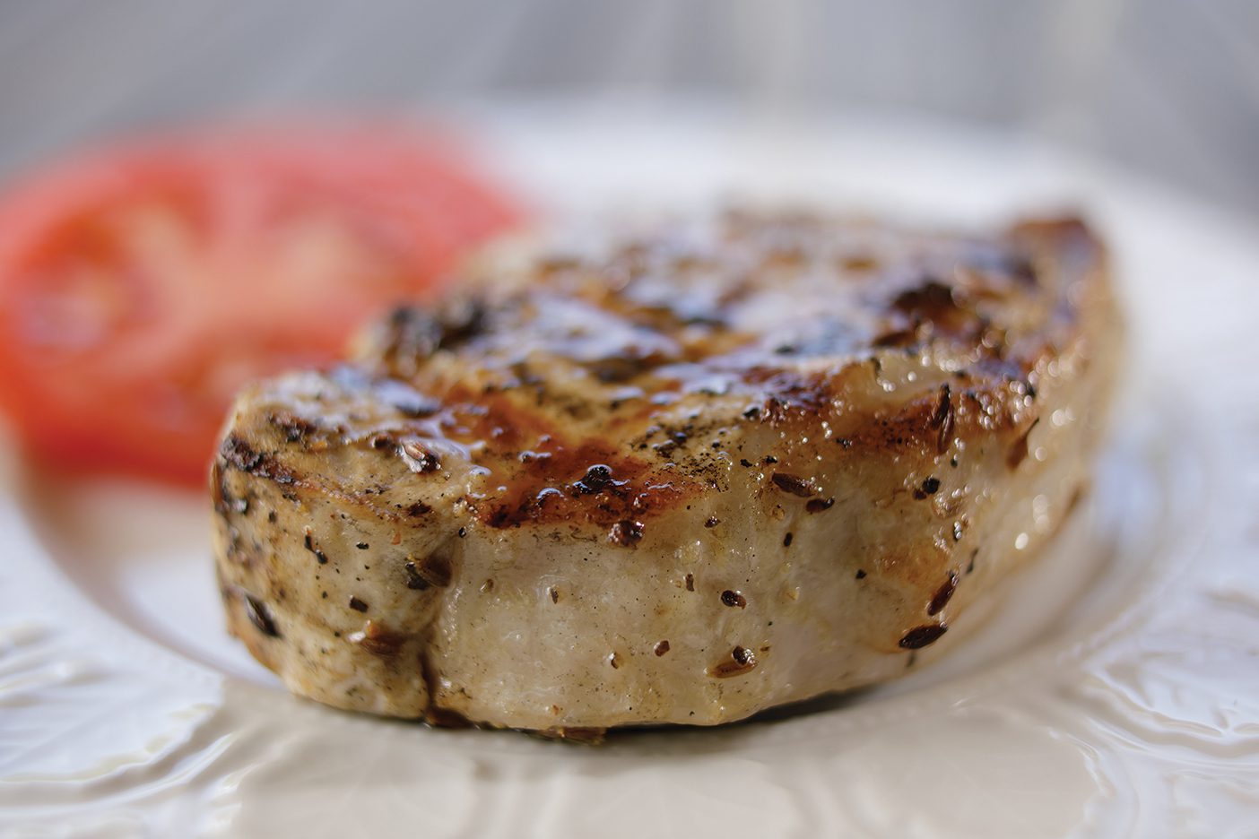 A pork chop on a white plate