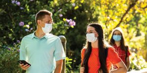 Two BYU students wearing mask walking outside.