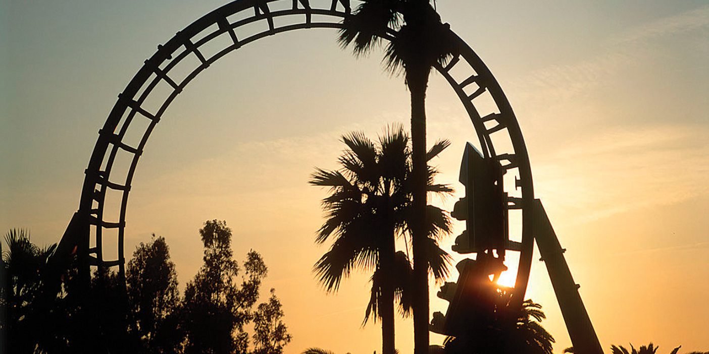 Roller coaster loop silhouetted at sunset