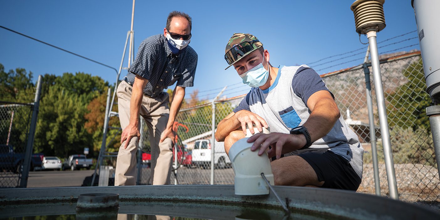 Two men take readings at BYU's weather station.