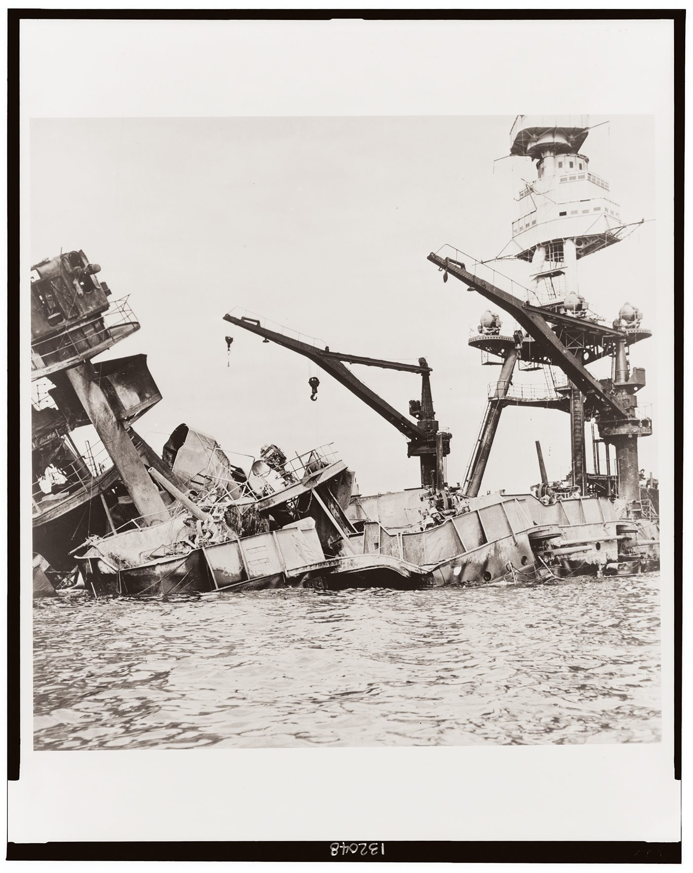 A sepia photo from 1941 shows the wreckage of the USS Arizona ship after the Attack on Pearl Harbor.