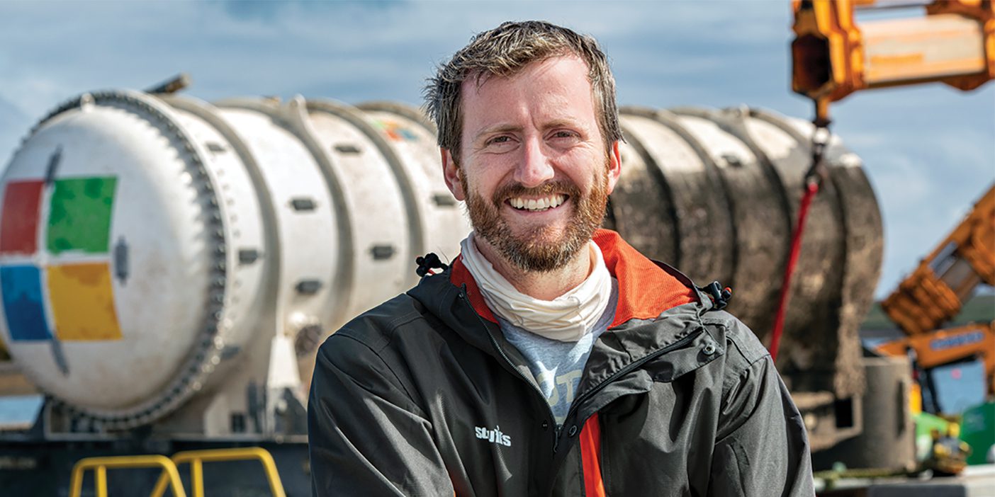 Spencer Fowers standing in front of an underwater computing lab.