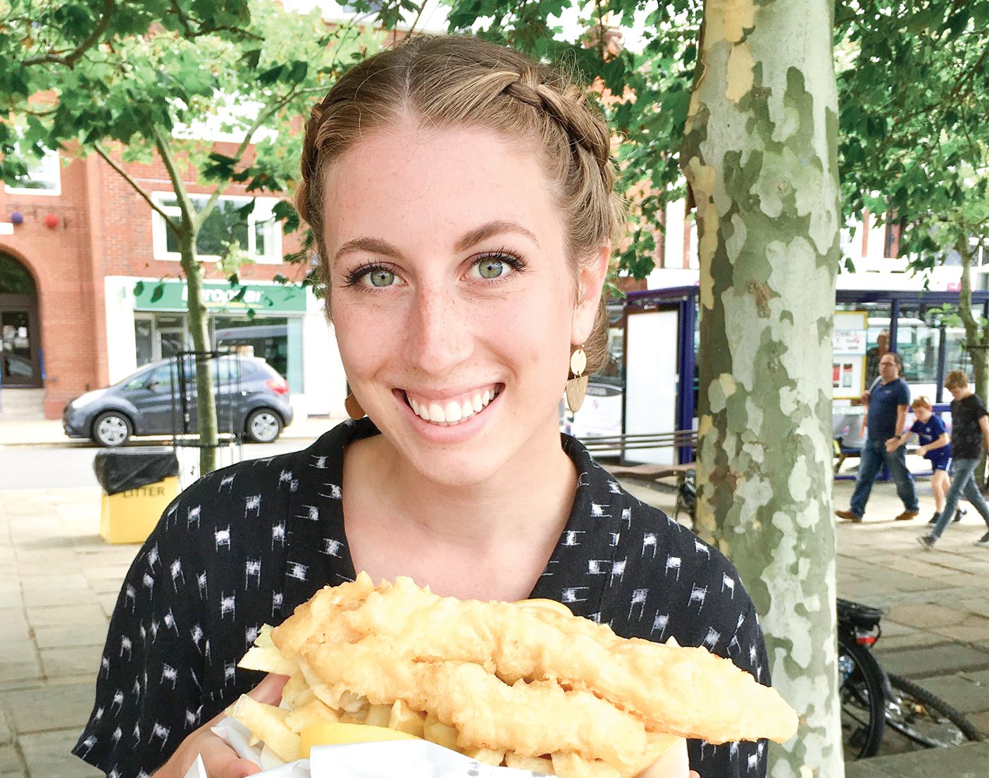 A portrait of Devynn Dayton holding a basket of fish and chips.