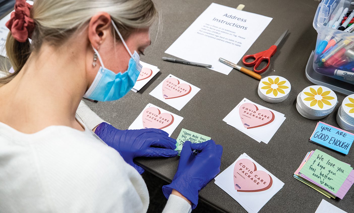 Masked woman creating COVID care packages.