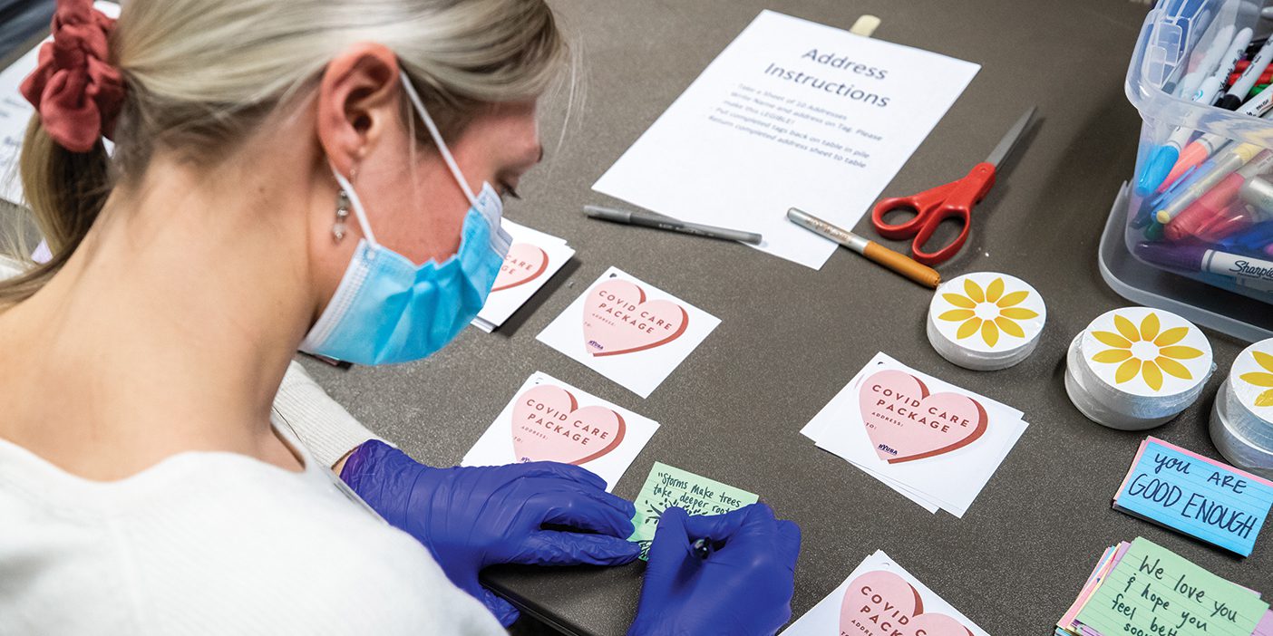 Masked woman creating COVID care packages.