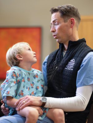 Doctor Adam J. Schow singing to a patient.