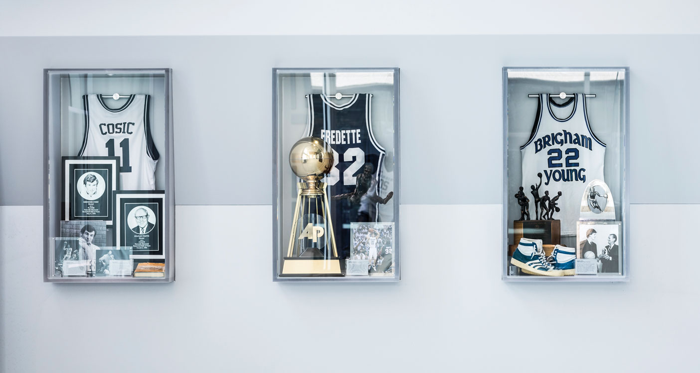 A line of jerseys and trophies in shadow boxes
