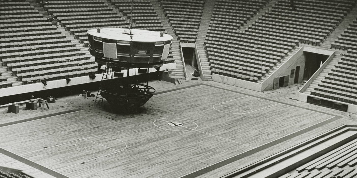 A black and white photo of construction inside the Marriott Center.
