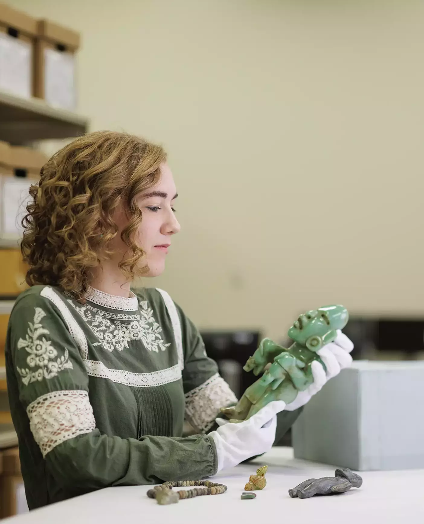 Student Chloe Burkey shifts through Mesoamerican greenstone figurines, looking for forgeries