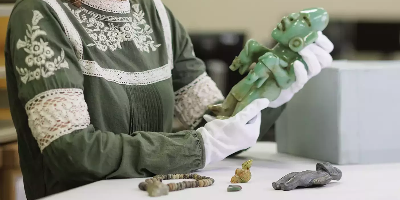 Student Chloe Burkey shifts through Mesoamerican greenstone figurines, looking for forgeries