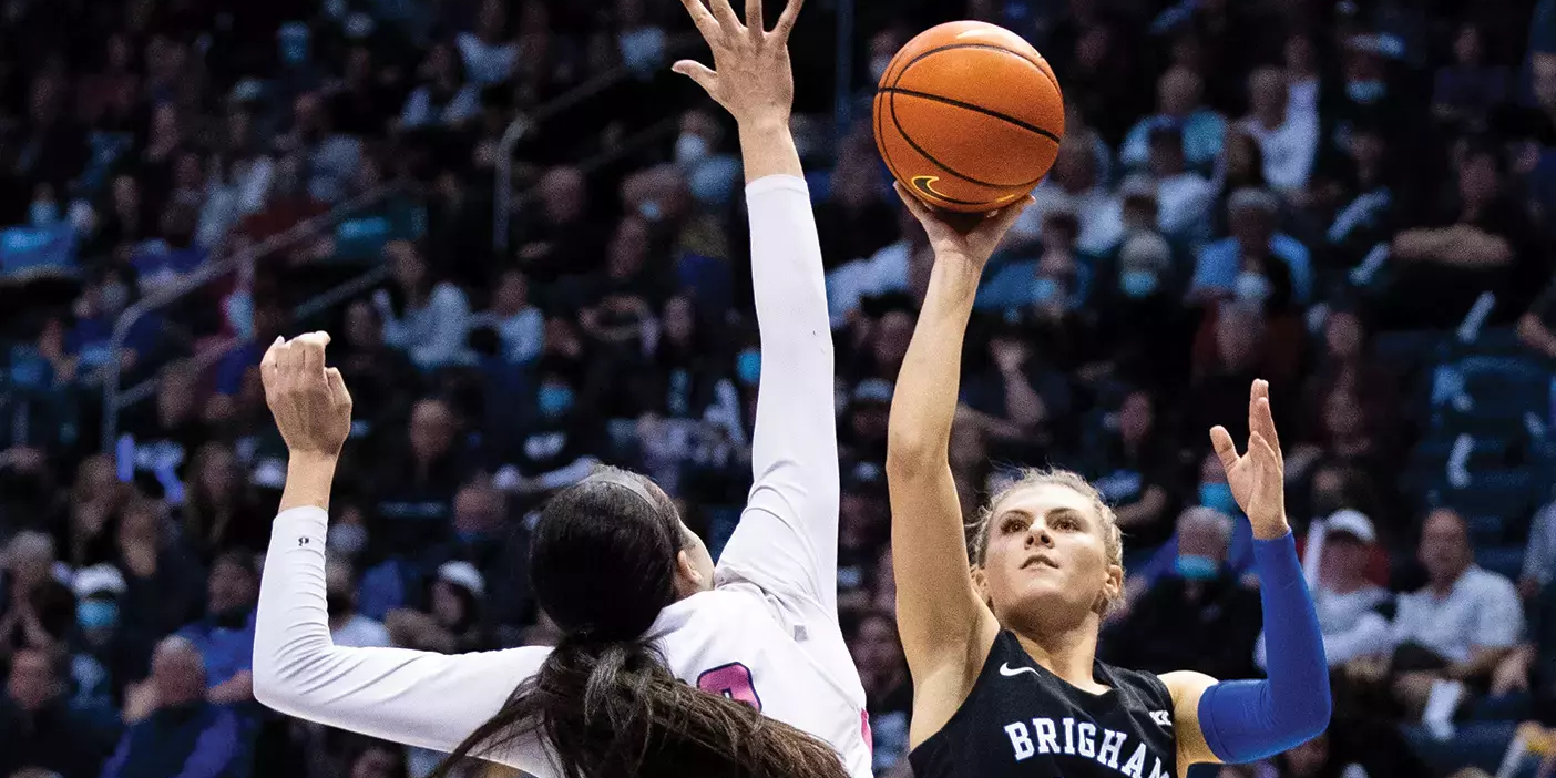 Senior guard Paisley Johnson Harding shoots a basket as a player from the opposing team tries to block her.