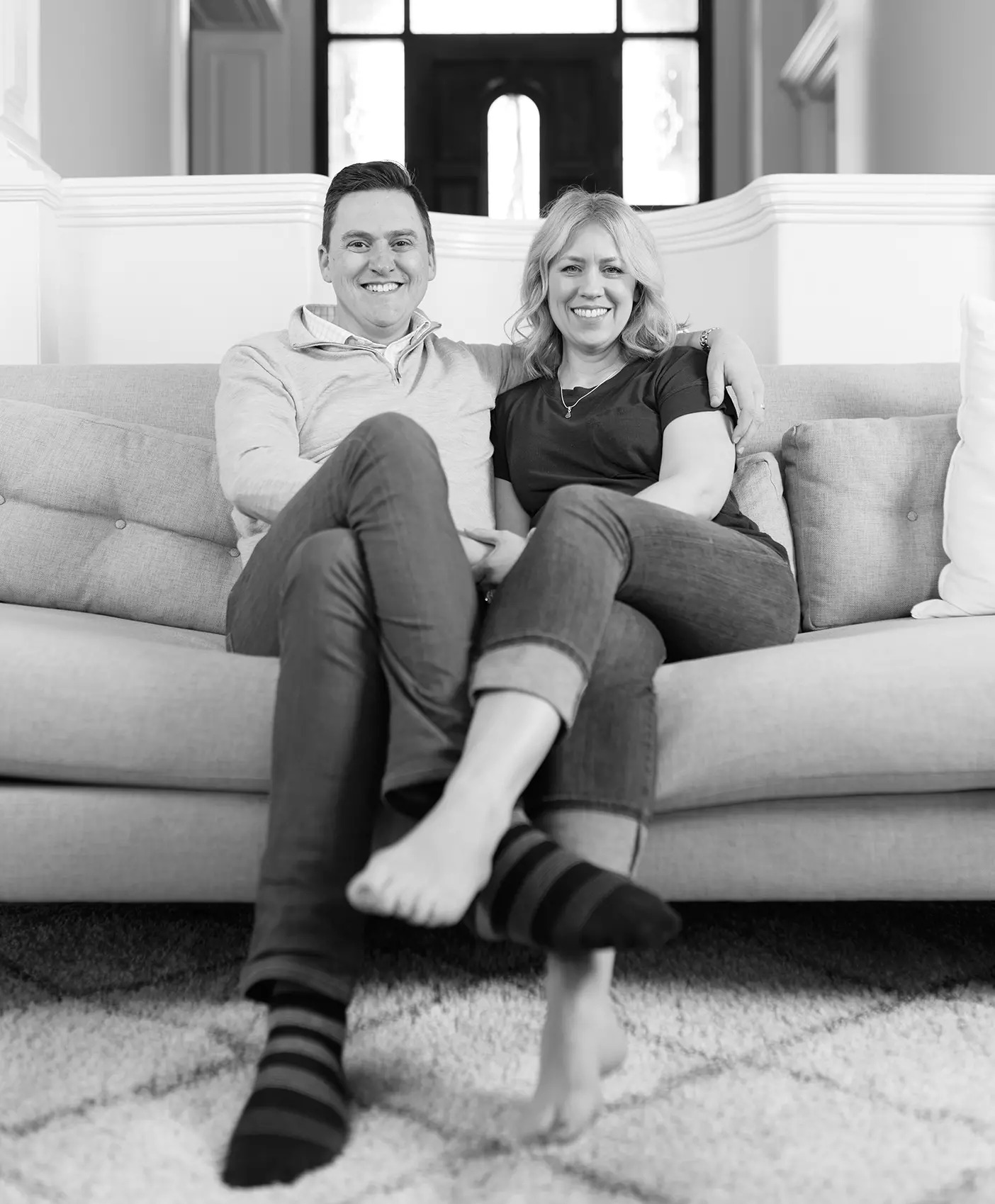 Greg and Anna McKeown sit together on a couch.