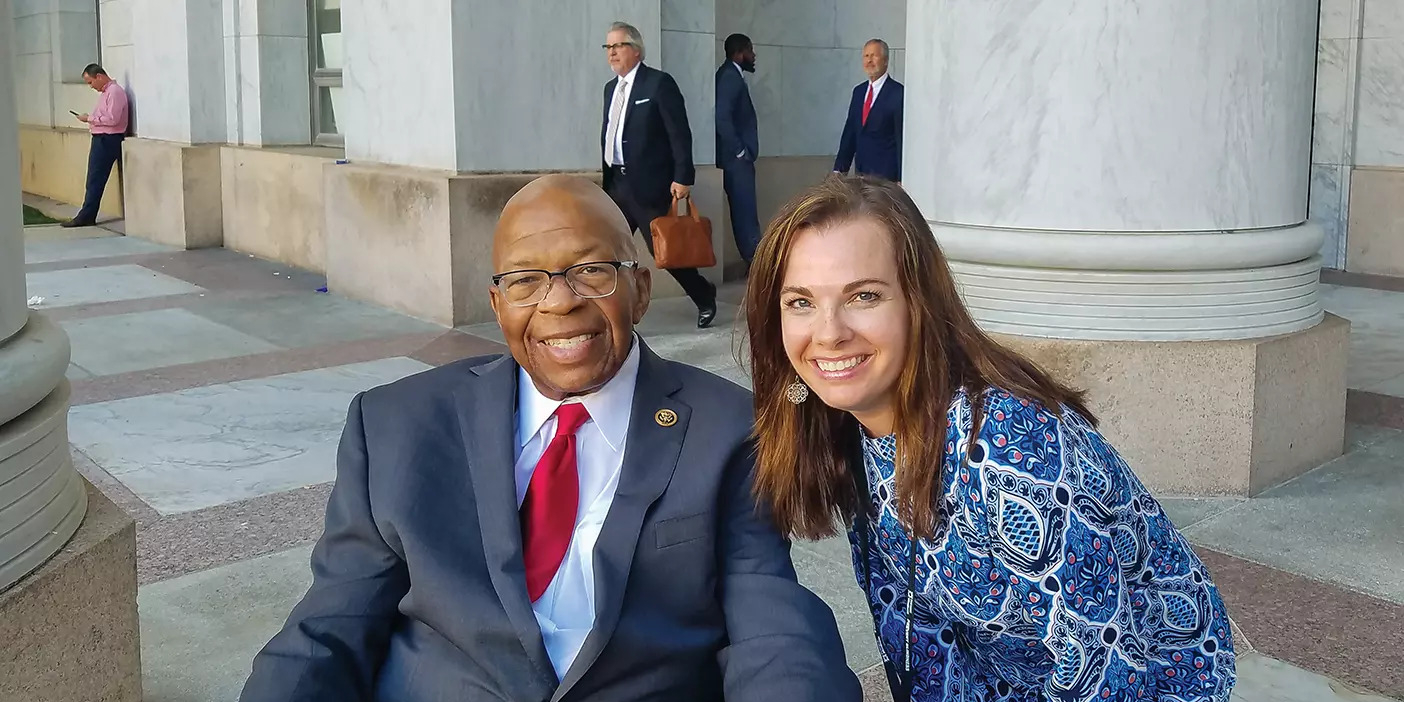 Catherine Carter meets with Maryland Congressman Elijah Cummings in Washington, DC. A woman wearing a blue dress poses with a man in a suit.