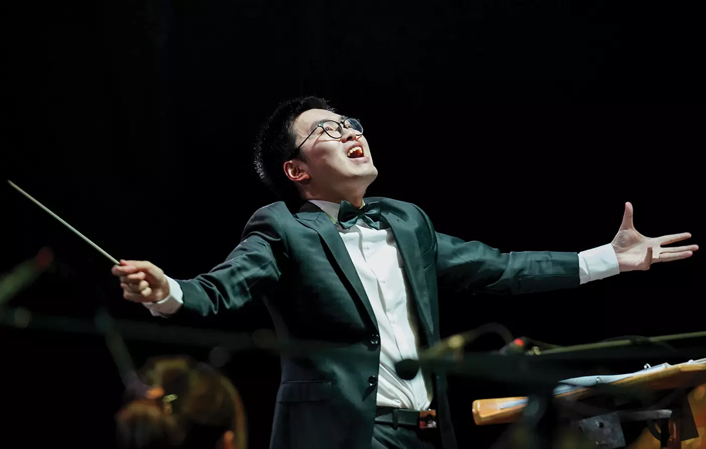 A Chinese man conducts a choir