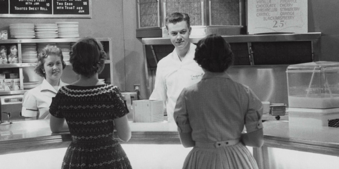 A black-and-white image of two women ordering ice cream from the BYU Creamery in the 1950s.