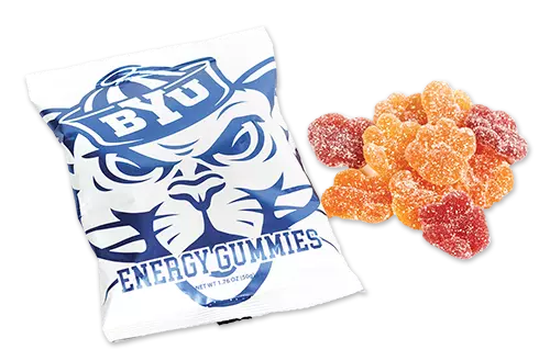 A pouch with a game-faced Cosmo the Cougar and the words "Energy Gummies" next to a pile of sweet and sour gummy snacks.