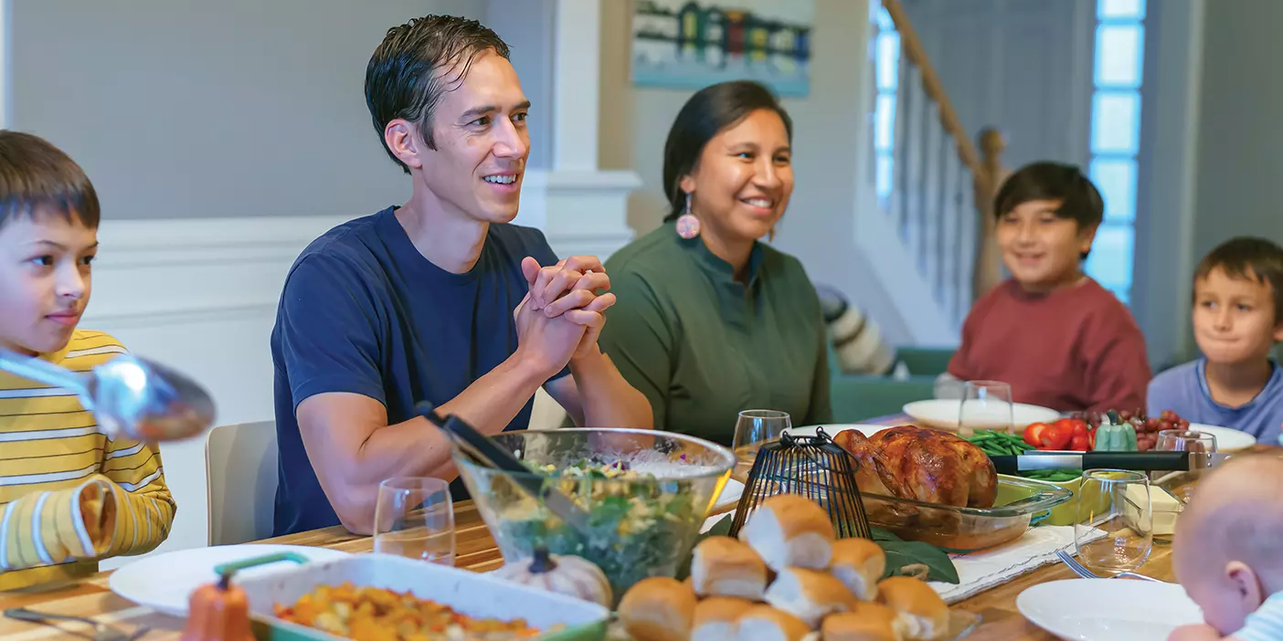 A family gathers at the dinner table to share time, stories, and food.