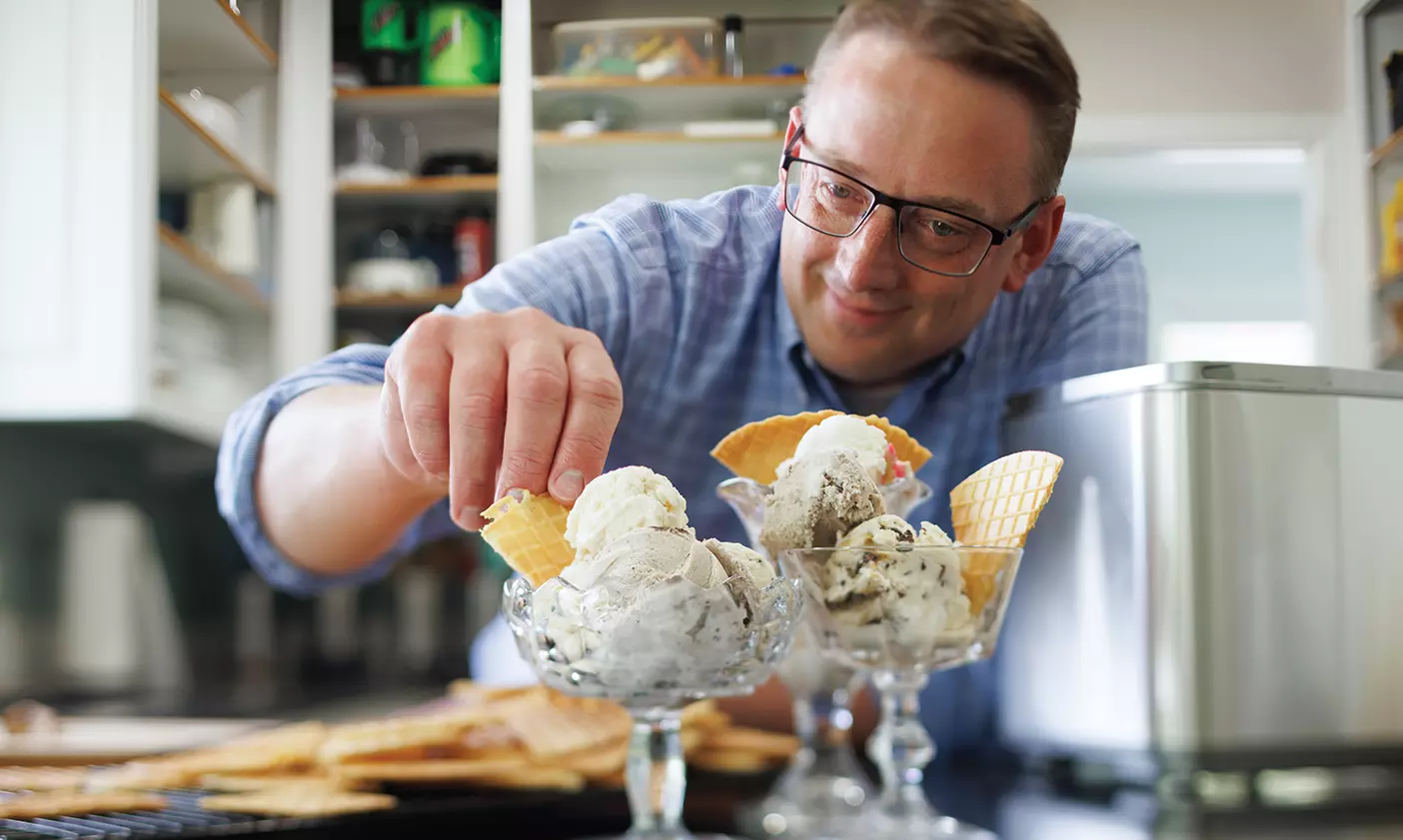 Professor Jacob Rawlins tops glass bowls of homemade ice cream with waffle chips.