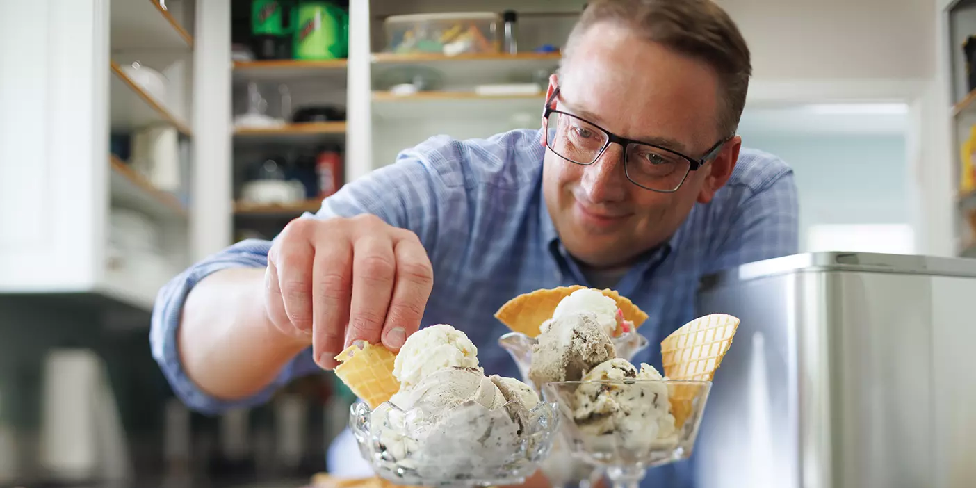 Professor Jacob Rawlins tops glass bowls of homemade ice cream with waffle chips.