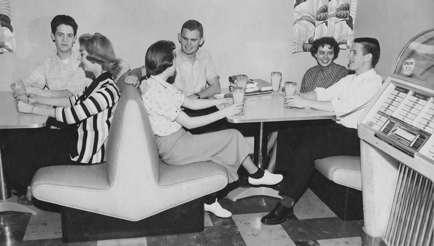 A black-and-white photo of a group of friends eating at the Cougareat snackbar in 1941.