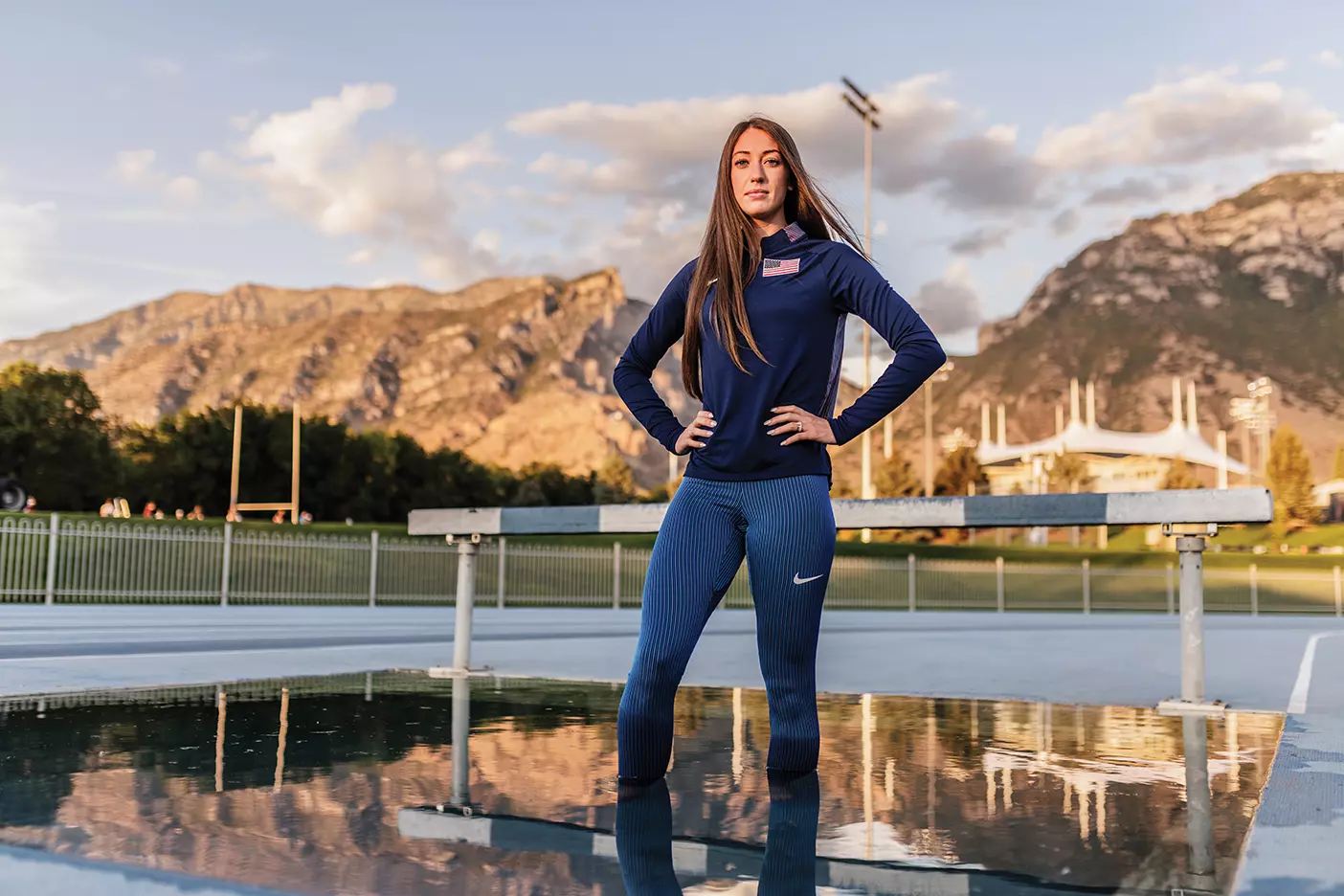 Former BYU track star Courtney Wayment stands in the water of a steeplechase hurdle pit.