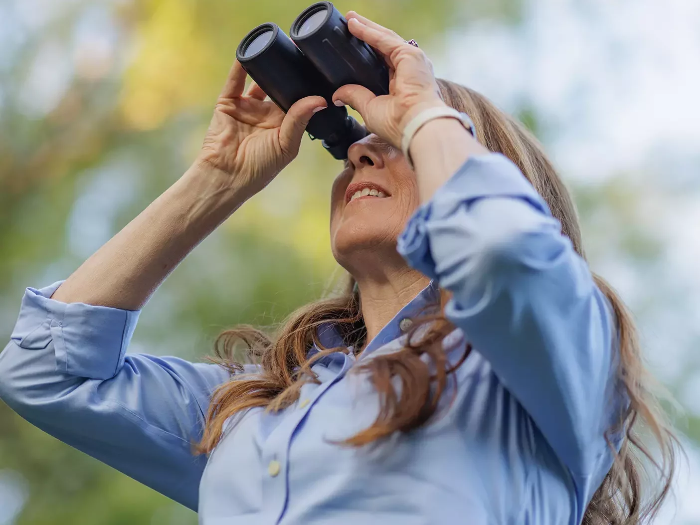 A woman peers through binoc